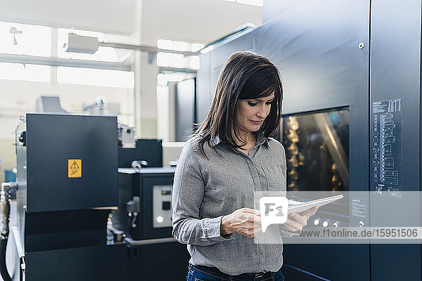 Businesswoman using tablet in a factory