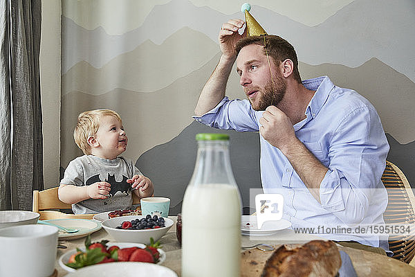 Vater und kleiner Sohn haben Spaß am Frühstückstisch