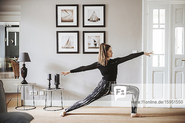 Woman practising yoga at home  warrior pose