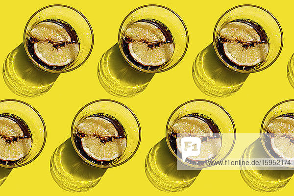 Muster von Reihen von Colagläsern mit Zitronenscheiben