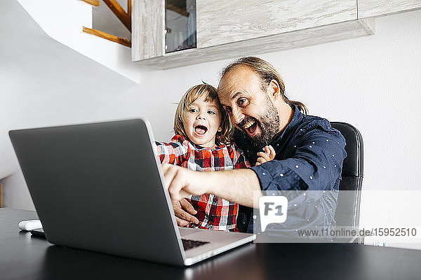 Happy father with daughter having a video chat at desk
