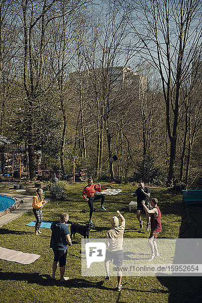 Gruppe von Freunden beim gemeinsamen Workout im Garten
