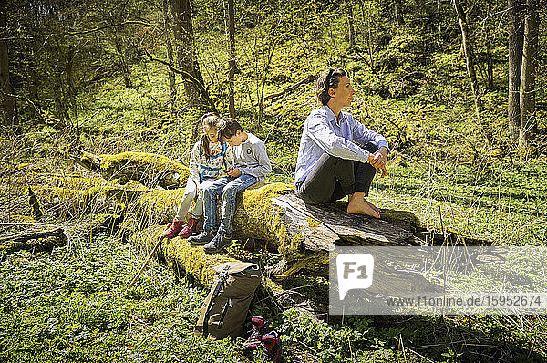 Frau erkundet Wald  während Kinder auf der Schwäbischen Alb nach Smartphones süchtig sind