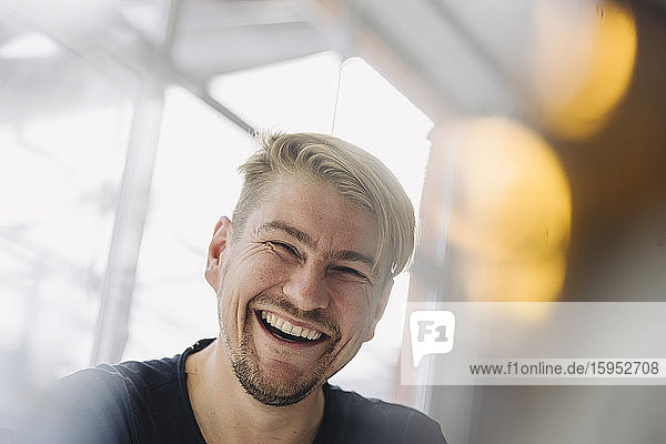 Portrait of a laughing man at the window