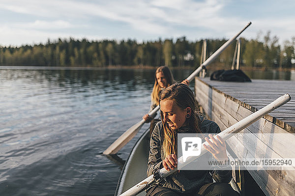 Two young women boating on lake