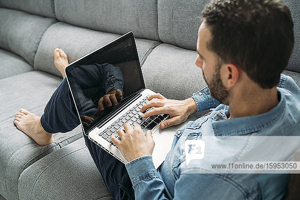 Schrägansicht eines Geschäftsmannes mit einem Laptop bei der Arbeit von zu Hause während des Ausbruchs der Coronavirus-Pandemie  Almeria  Spanien  Europa