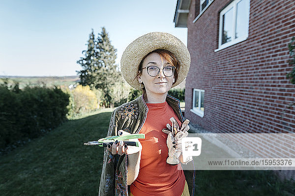 Bildnis einer Frau mit Gartenhandschuhen und Baumschere