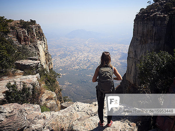 Rückenansicht einer Frau mit Rucksack  die auf einem Felsen steht und die Aussicht geniesst  Tundavala  Angola