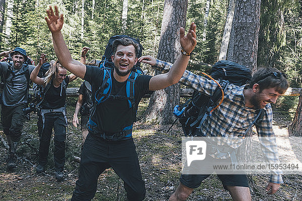 Young people backpacking in nature  laughing and waving at camera