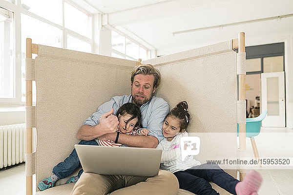 Father distracted by two daughters in home office