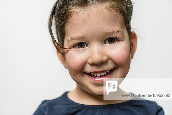 Porträt eines glücklichen Mädchens vor weissem Hintergrund