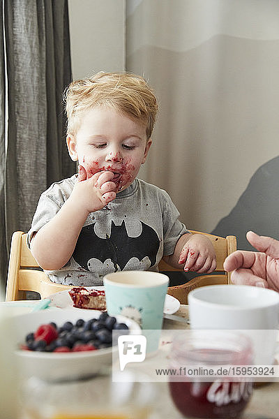 Portrait of little boy eating bread with jam