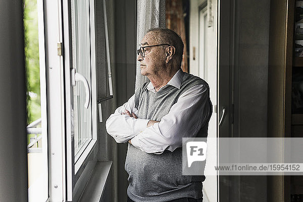 Nachdenklicher älterer Mann schaut aus dem Fenster