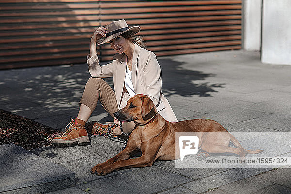 Modische Frau mit ihrem Hund in der Stadt