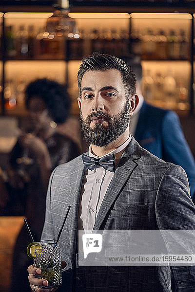 Porträt eines jungen Mannes bei einem Cocktail in einer Bar