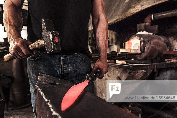 Messermacher bei der Arbeit  Stahlsplitter beim Hämmern von Damaststahl