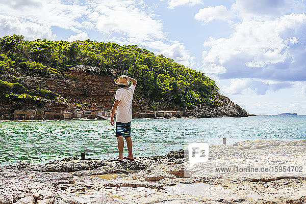 Rückenansicht eines auf einer Klippe stehenden Mannes mit Blick aufs Meer  Cala Benirras  Ibiza  Spanien