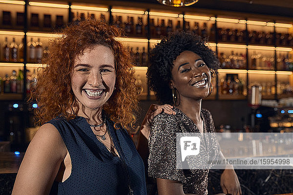Porträt von zwei glücklichen jungen Frauen in einer Bar