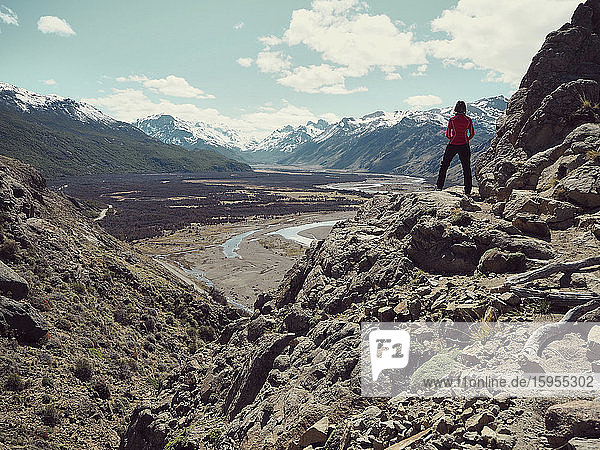 Rückansicht einer Frau in voller Länge  die auf einem Felsen steht und die Berge bewundert  El Chalten  Argentinien