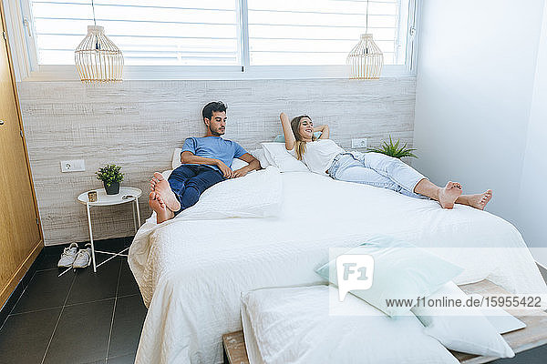 Paar entspannt sich zu Hause auf dem Bett im Schlafzimmer