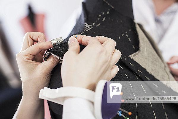 Close-up of seamstress pinning suit jacket
