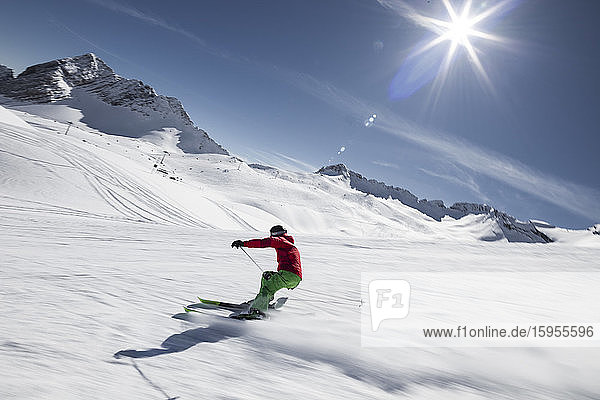 Deutschland  Bayern  Garmisch-Partenkirchen  Sonne scheint über Mann beim Skifahren auf der Zugspitze