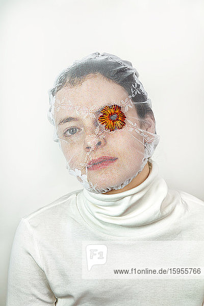 Bildnis einer jungen Frau mit weißem Schleier und einer Blume  die ein Auge bedeckt