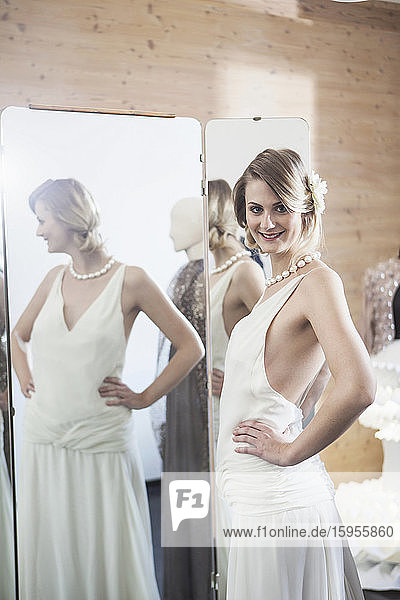 Smiling bride fitting her dress in studio