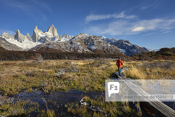 Man walking on boardwalk in front of Mount Fitz Roy in Autumn  El Chalten  Patagonia  Argentina