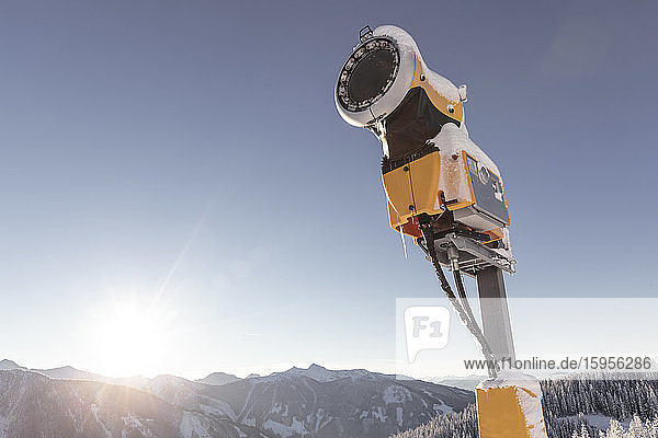 Österreich,  Steiermark,  Schladming,  Niedrigwinkelansicht einer Schneekanone,  die bei Sonnenuntergang vor klarem Himmel steht