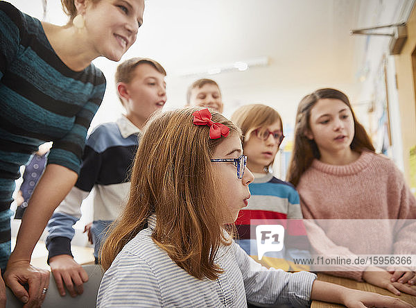 Kinder lernen am Computer mit einem Lehrer