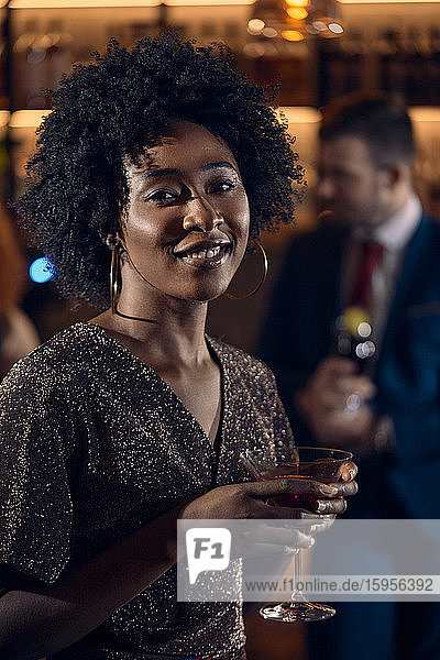 Porträt einer jungen Frau bei einem Cocktail in einer Bar