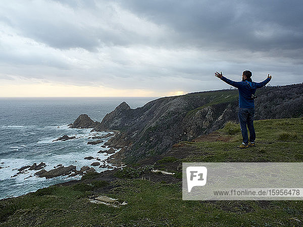 Man enjoying the view from the cliffs and the ocean at sundown  Plettenberg Bay  South Africa