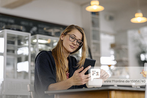 Young woman using smartphone in a cafe