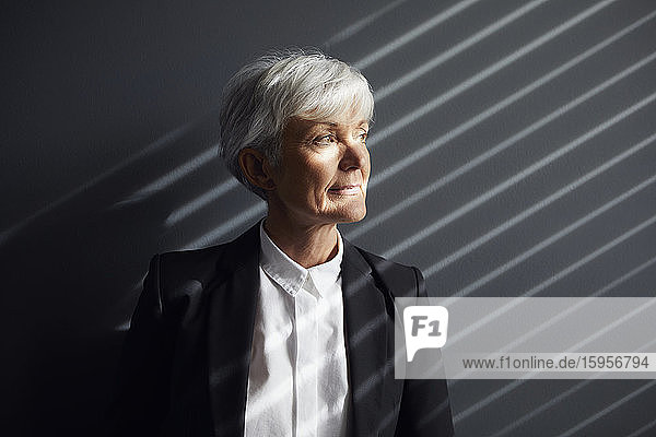 Porträt einer nachdenklichen älteren Geschäftsfrau  die in die Ferne schaut