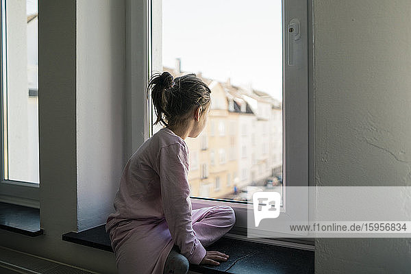 Kleines Mädchen schaut aus dem Fenster