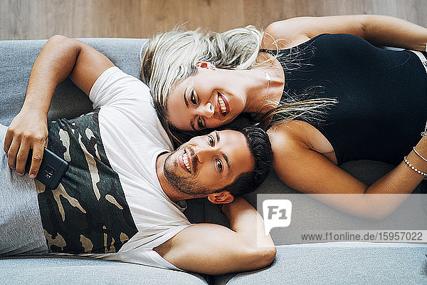 Porträt eines glücklichen Paares  das sich gemeinsam auf der Couch entspannt