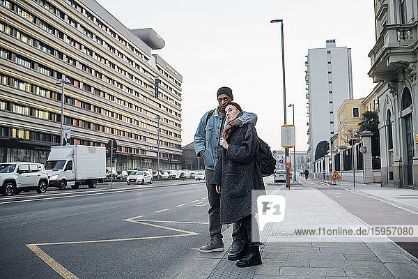 Young couple standing at the roadside in the city  Milan  Italy