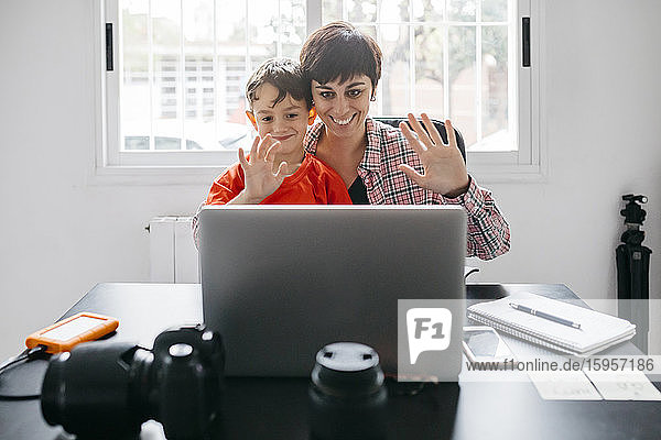 Mutter und Sohn nutzen Laptop für einen Videoanruf zu Hause