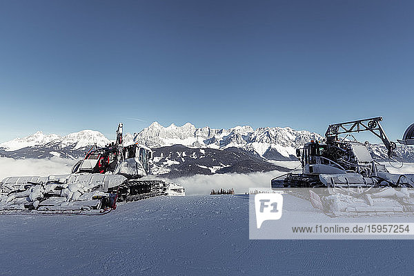 Österreich  Steiermark  Schladming  klarer Himmel über zwei Schneepflüge und Dachsteinmassiv