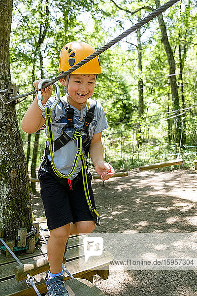 Boy on a high rope course in forest