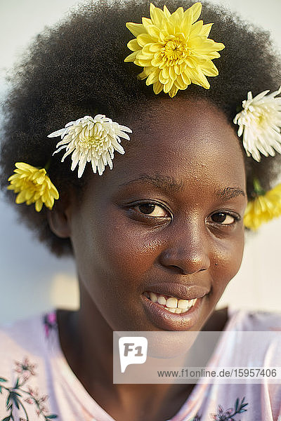 Porträt einer lächelnden jungen Frau mit Blumen
