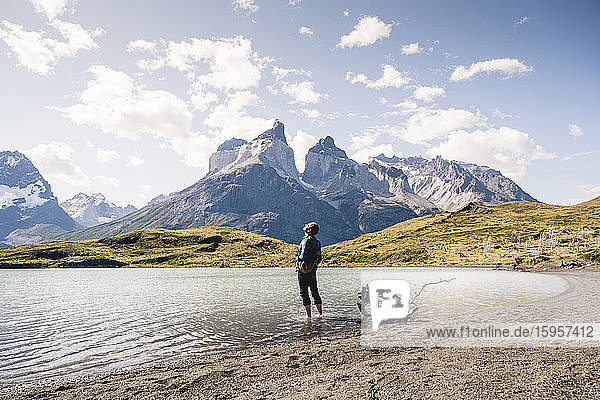 Hiker in mountainscape standing in a lake in Torres del Paine National Park  Patagonia  Chile