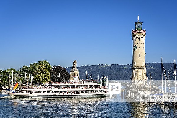 Excursion ship leaves the harbour  New Lindau lighthouse and the Bavarian lion in the harbour on the island  Lindau island  Lindau on Lake Constance  Swabia  Germany  Europe
