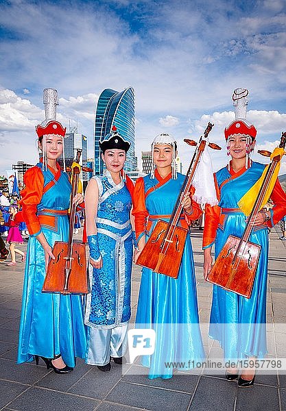 Mongolische Mädchen in traditioneller Tracht und mit dem nationalen Musikinstrument Morin huur posierend  der Sukhbaatar-Platz  Hauptstadt von Ulaanbaatar  Mongolei  Asien