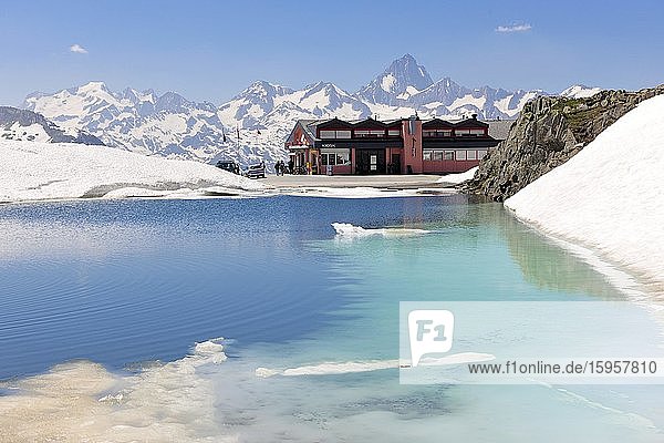 Pass Nufenenpass with snow  restaurant and small mountain lake  behind snow-covered peaks Finsteraarhorn on the left and Lauteraarhorn on the right  Lepontine Alps  Ulrichen  Canton Valais  Switzerland  Europe