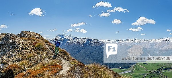 Wanderer auf dem Berggipfel von Mount Alfred  Ausblick auf schneebedeckte Berglandschaft  Glenorchy bei Queenstown  Südliche Alpen  Otago  Südinsel  Neuseeland  Ozeanien
