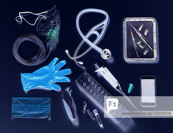 Potentieller Ausweg aus der Abriegelungsphase. Medizinische Ausrüstung auf schwarzem Hintergrund  Sauerstoffmaske  Stethoskop  Mobiltelefon mit einer Kontaktverfolgungs-App  Impfstoffspritzen  blaue Handschuhe und Digitalthermometer.