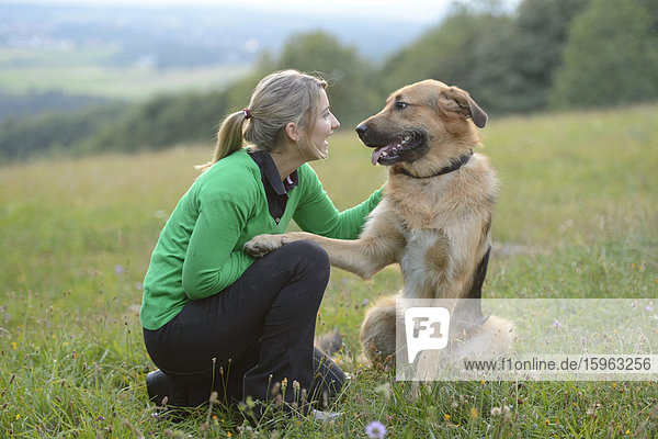 Teenage girl and dog in meadow