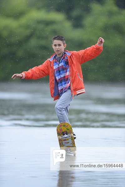 Boy with skateboard on a rainy day